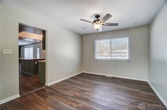 empty room featuring ceiling fan and dark hardwood / wood-style flooring