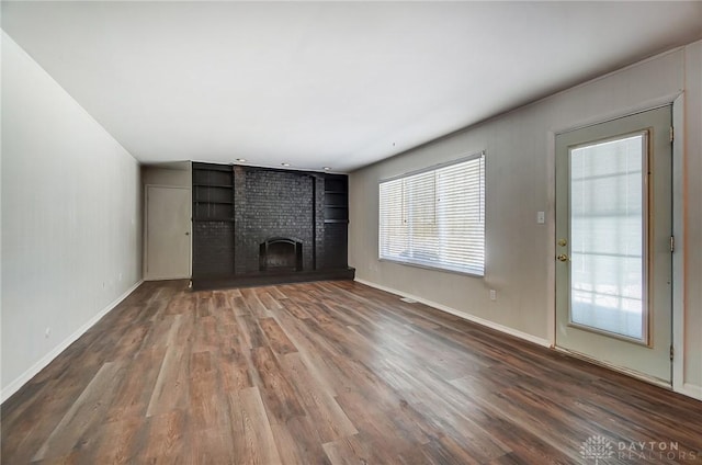 unfurnished living room with a fireplace and dark hardwood / wood-style flooring