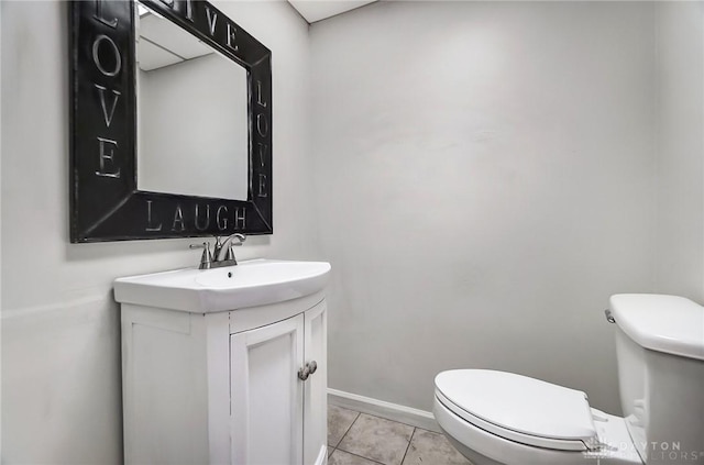 bathroom with toilet, vanity, and tile patterned flooring