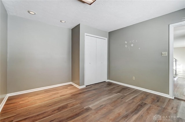 unfurnished bedroom featuring a closet and hardwood / wood-style flooring