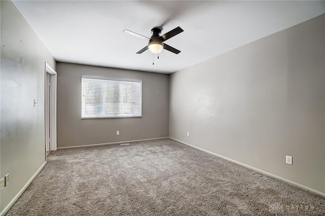 carpeted spare room with ceiling fan