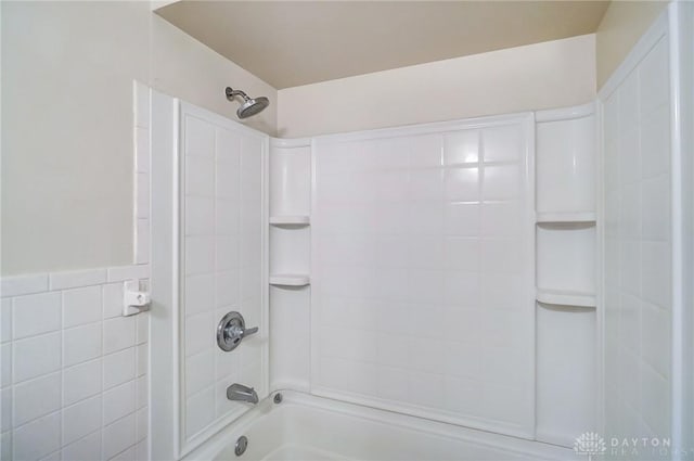 bathroom with tile walls and tiled shower / bath combo