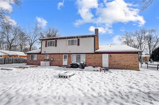 view of snow covered back of property