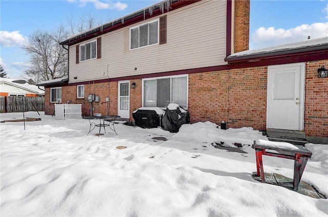 snow covered house with central air condition unit