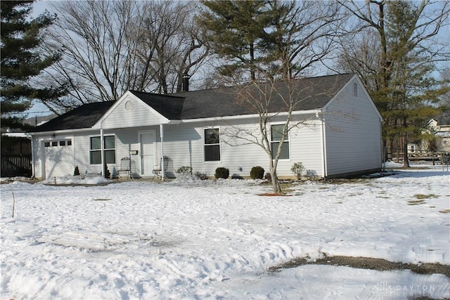 snow covered house with a garage