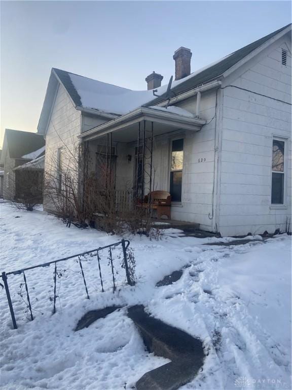 view of snow covered exterior featuring a porch