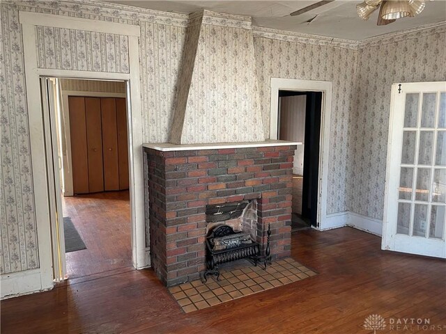 unfurnished living room featuring a fireplace, dark wood-type flooring, and ceiling fan