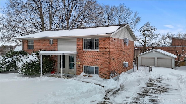 snow covered house featuring an outbuilding and a garage