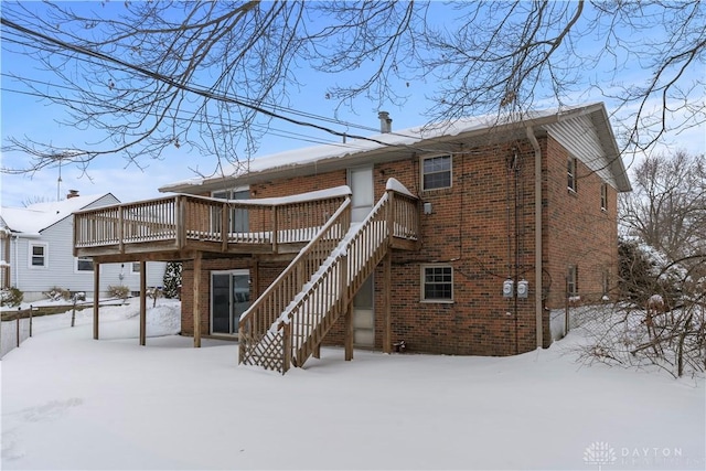 snow covered rear of property featuring a wooden deck