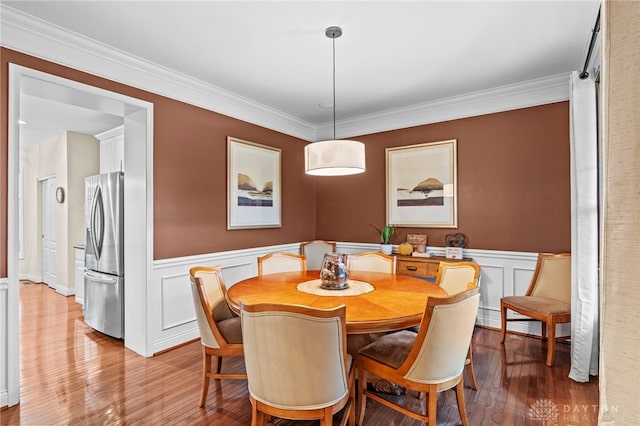 dining room with crown molding and light hardwood / wood-style floors