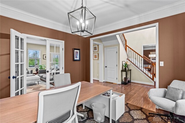 dining space featuring crown molding, french doors, and a notable chandelier