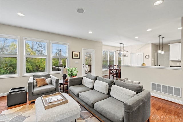 living room with a chandelier and light wood-type flooring