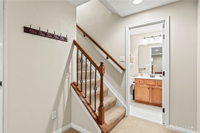 staircase featuring sink and carpet flooring