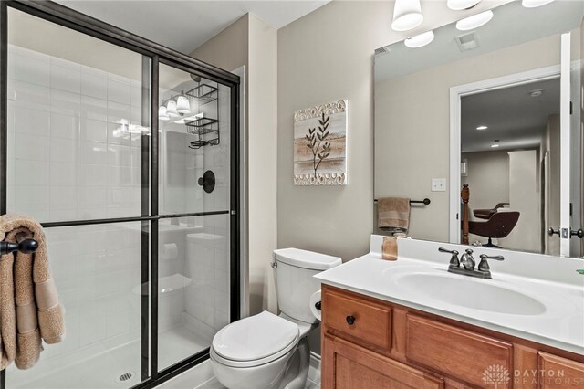 bathroom featuring toilet, walk in shower, and vanity