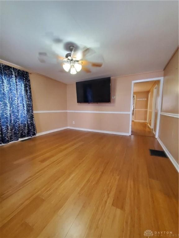 unfurnished living room featuring ceiling fan and wood-type flooring