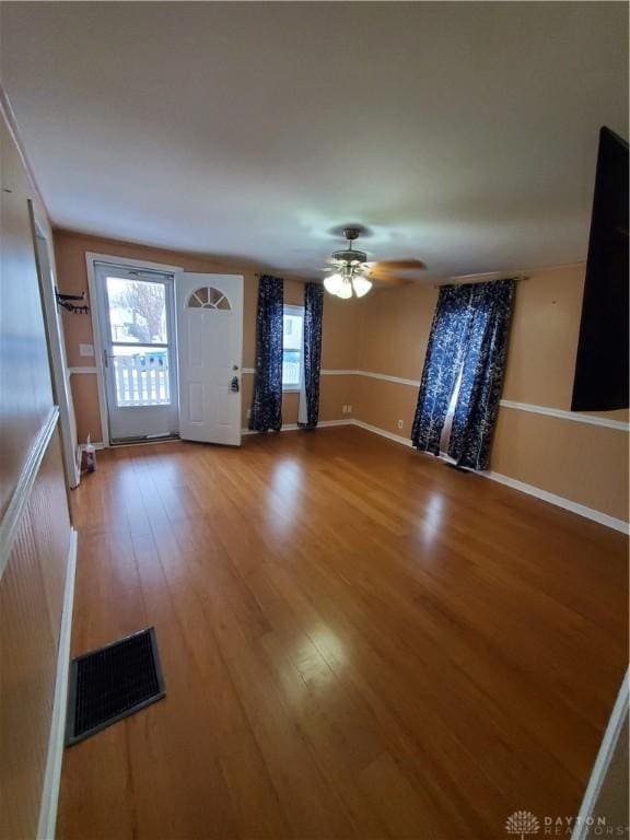 unfurnished living room with ceiling fan and wood-type flooring