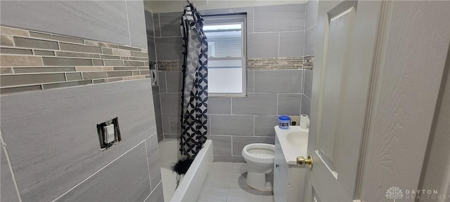 full bathroom featuring toilet, a healthy amount of sunlight, shower / bath combo, and vanity