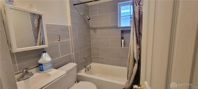 full bathroom featuring sink, tile walls, toilet, and shower / bathtub combination with curtain