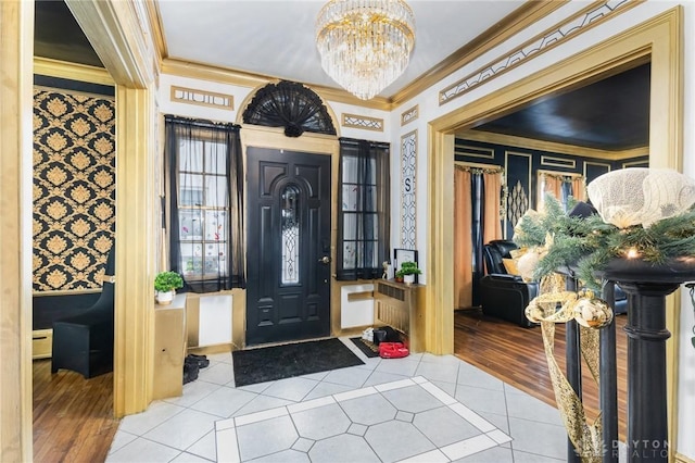 tiled entrance foyer featuring crown molding, a baseboard radiator, and a notable chandelier