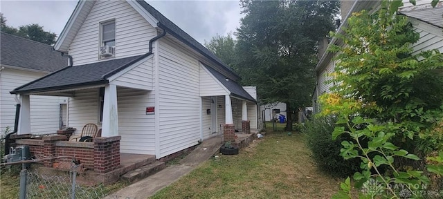 view of property exterior featuring covered porch and a yard