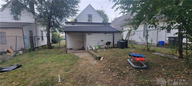 back of property featuring central AC unit and a lawn