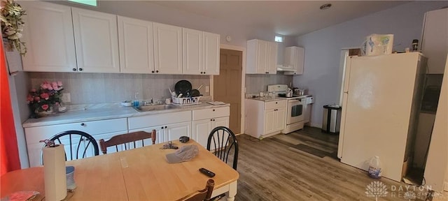 kitchen featuring white appliances, white cabinetry, wood-type flooring, sink, and backsplash