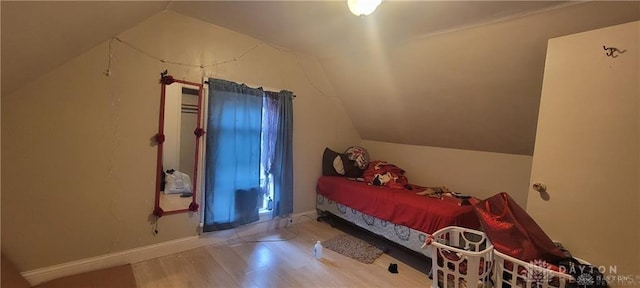 bedroom with hardwood / wood-style flooring and lofted ceiling