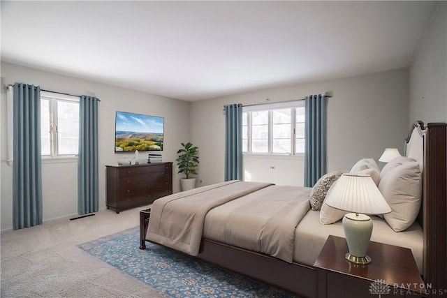 carpeted bedroom featuring multiple windows