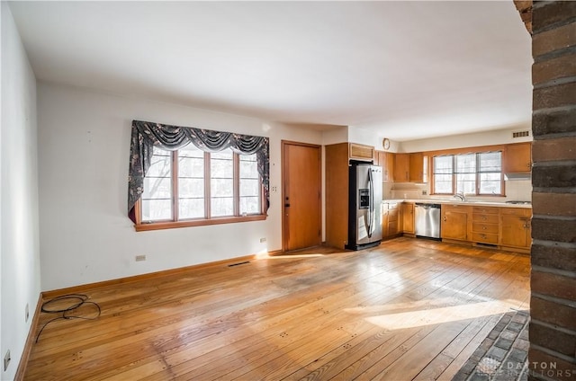 kitchen with light wood-type flooring, stainless steel appliances, and sink