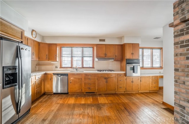 kitchen featuring a wealth of natural light, appliances with stainless steel finishes, sink, and light hardwood / wood-style floors