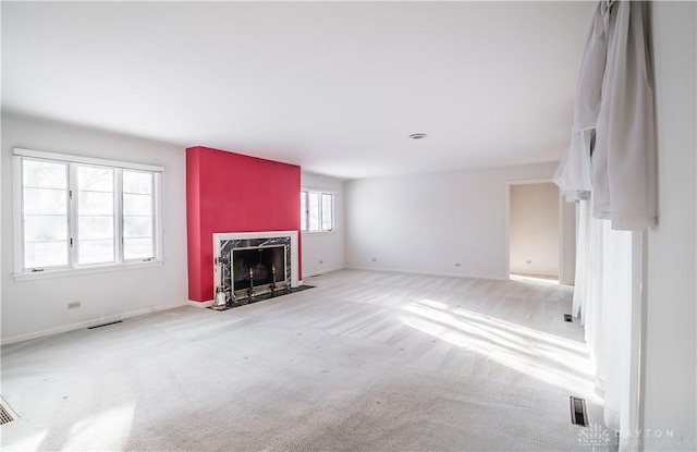 unfurnished living room with light carpet and a fireplace