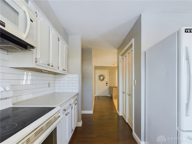 kitchen with white cabinetry, white appliances, dark hardwood / wood-style floors, and tasteful backsplash