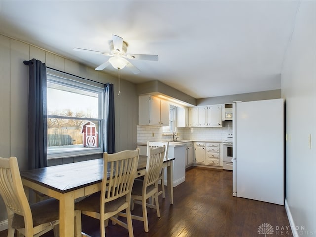 kitchen with tasteful backsplash, ceiling fan, white appliances, dark wood-type flooring, and white cabinets