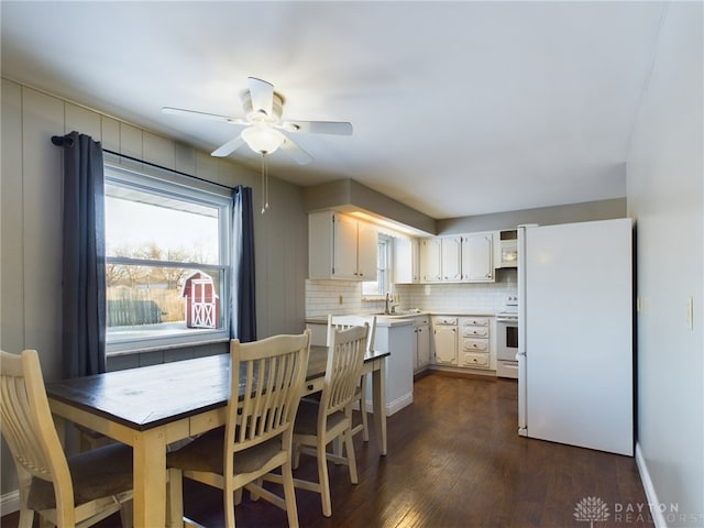 kitchen with ceiling fan, backsplash, sink, white appliances, and white cabinetry