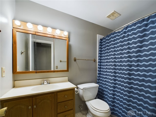 bathroom featuring toilet, vanity, and tile patterned flooring