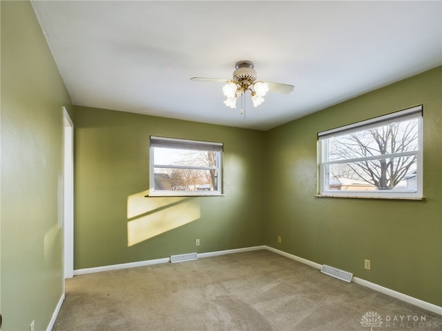 carpeted spare room featuring ceiling fan