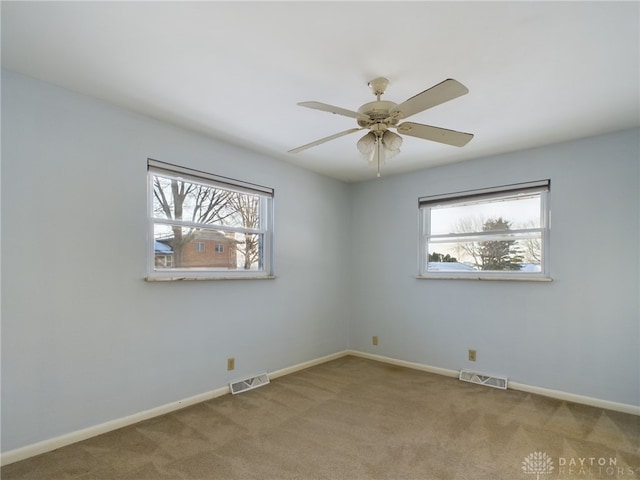 unfurnished room featuring carpet floors, plenty of natural light, and ceiling fan