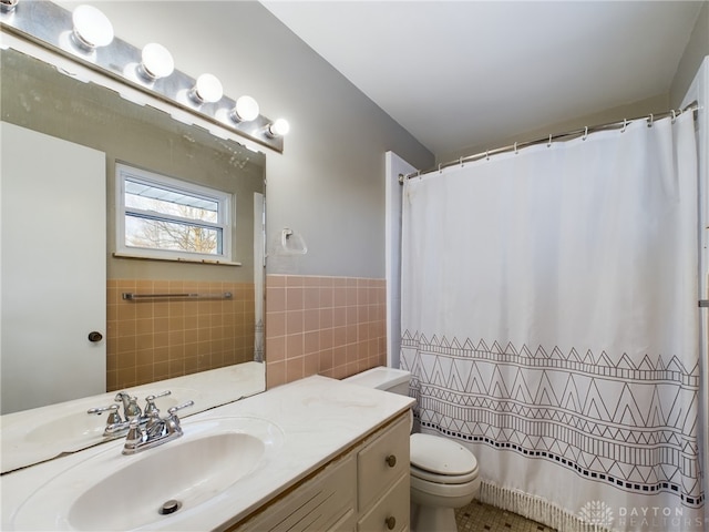 bathroom featuring toilet, a shower with shower curtain, tile walls, and vanity