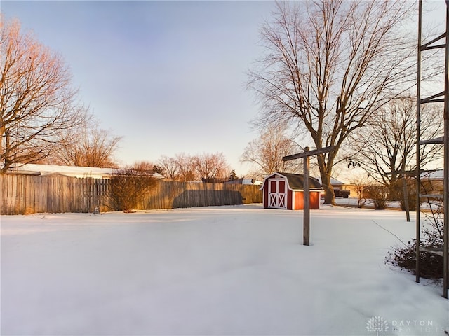 yard layered in snow with a storage unit