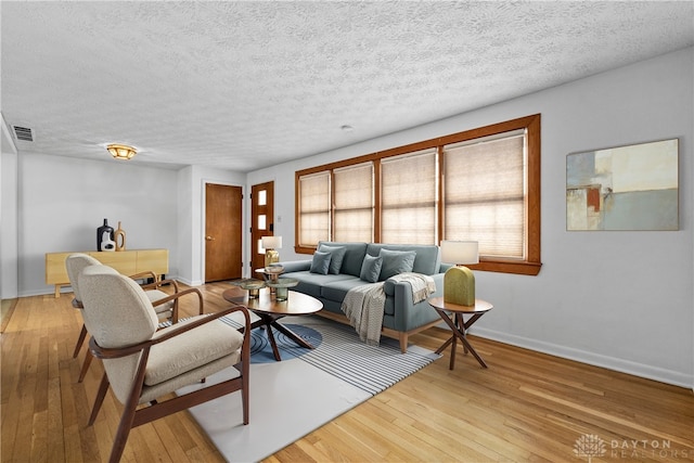 living room featuring a textured ceiling and light hardwood / wood-style flooring