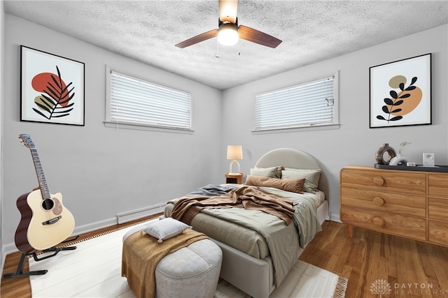 bedroom featuring ceiling fan, a textured ceiling, and light hardwood / wood-style flooring