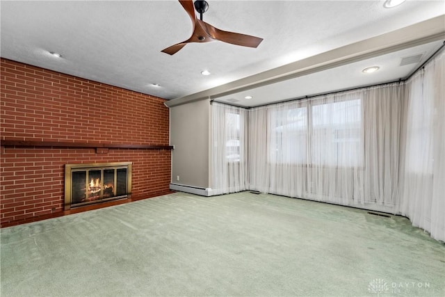 unfurnished living room with carpet, ceiling fan, a brick fireplace, a textured ceiling, and brick wall