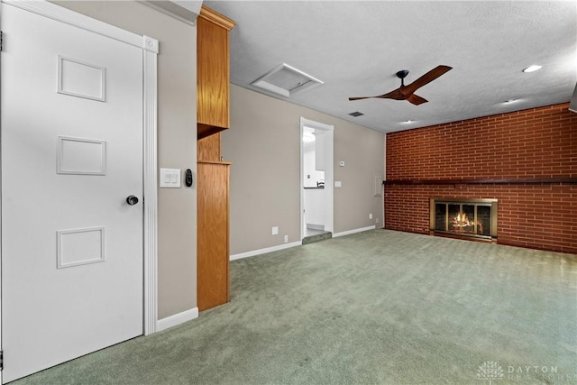 unfurnished living room with a textured ceiling, brick wall, carpet floors, ceiling fan, and a brick fireplace