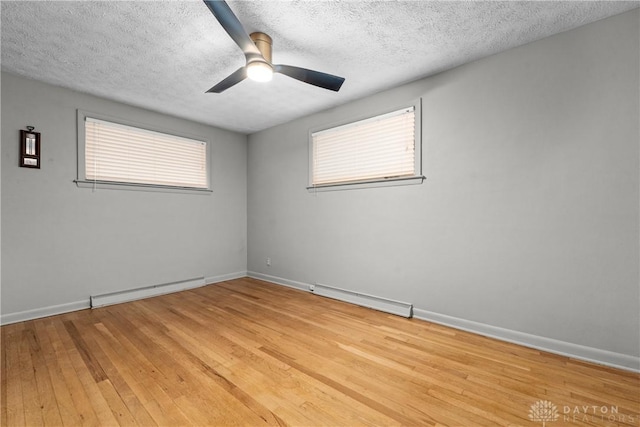 unfurnished room featuring light wood-type flooring, ceiling fan, a textured ceiling, and a baseboard radiator