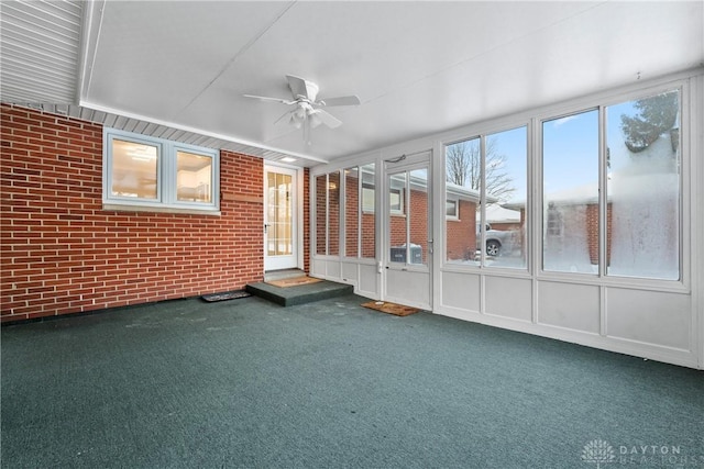 unfurnished sunroom featuring ceiling fan