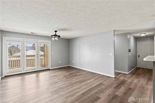 unfurnished room with a textured ceiling and hardwood / wood-style floors