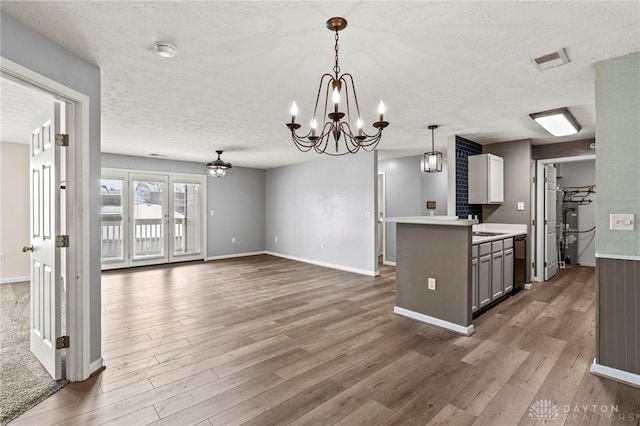 kitchen featuring decorative light fixtures, a textured ceiling, dark hardwood / wood-style flooring, and gray cabinets