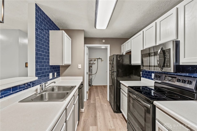 kitchen featuring backsplash, appliances with stainless steel finishes, sink, and white cabinetry