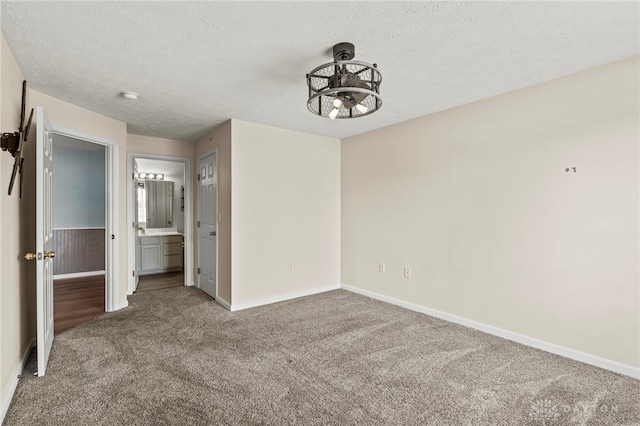 carpeted empty room featuring a textured ceiling