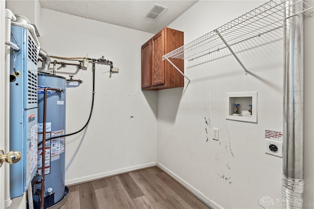 laundry area featuring light hardwood / wood-style floors, hookup for an electric dryer, gas water heater, washer hookup, and cabinets